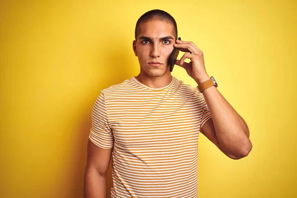 Mladý Pohledný Muž Mluví Pomocí Smartphone Přes Žluté Izolované Pozadí — Stock fotografie