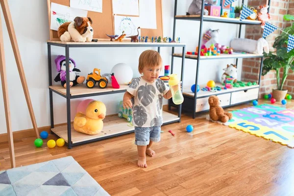 Чарівний Малюк Тримає Пляшку Годування Навколо Великої Кількості Іграшок Дитячому — стокове фото