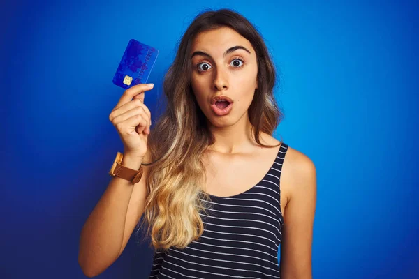Ung Vacker Kvinna Som Håller Kreditkort Över Blå Isolerad Bakgrund — Stockfoto