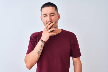 Soyutlanmış arka planda duran yakışıklı genç adam ağzıyla esnemekten sıkılmış. Huzursuz ve uykulu..