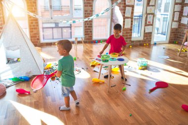 Anaokulunda bir sürü oyuncakla oynayan sevimli çocuklar.