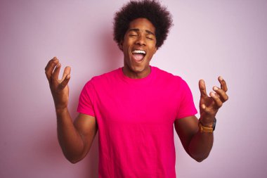 Siyah saçlı genç Amerikalı adam pembe arka planda dikilip başarının çılgınlığını kollarını kaldırarak ve gözlerini kapayarak heyecanla haykırarak kutluyor. Kazanan konsept