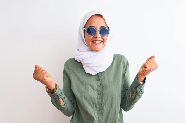 孤立した背景にヒジャーブと夏のサングラスをかけている若いアラブ人女性は 腕を上げて目を開いて成功したことに驚いて驚いて驚いています 勝者のコンセプト — ストック写真
