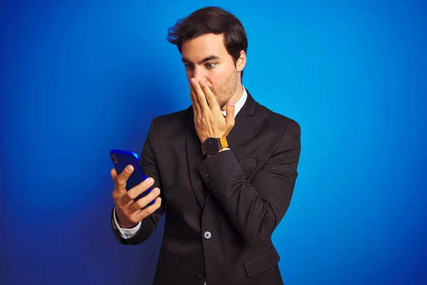 Młody Przystojny Biznesmen Pomocą Smartfona Stojącego Nad Odizolowanym Niebieskim Tłem — Zdjęcie stockowe