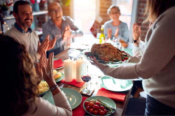 伝統的な料理と装飾でクリスマスの前夜を祝う家で家族や友人の食事 誇りに思って七面鳥料理を示す — ストック写真