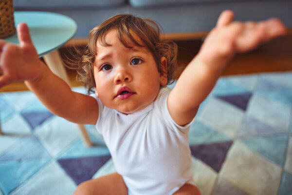 Beautiful toddler child girl wearing white t-shirt playing on the carpet