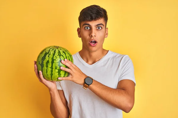 Young Indian Shopkeeper Man Holding Watermelon Standing Isolated Yellow Background — Stock Photo, Image