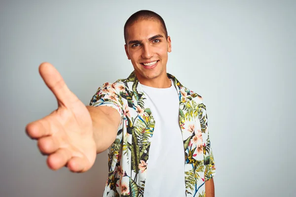 年轻英俊的男子在假日穿着夏威夷衬衫白底笑友好地握手表示问候和欢迎 成功的业务 — 图库照片