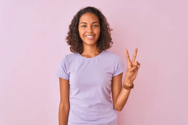 年轻的巴西妇女穿着T恤站在孤立的粉红色背景显示和指着手指二号 同时微笑自信和快乐 — 图库照片
