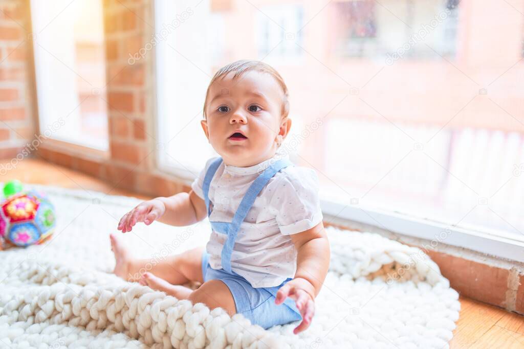 Beautiful toddler sitting on the blanket at kindergarten