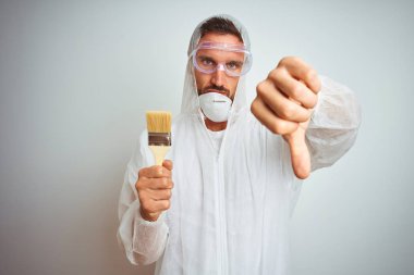 Profesyonel işçi ekipmanı giyen ressam izole edilmiş arka planda fırça tutuyor kızgın bir yüz, olumsuz işaret baş parmakları aşağıda, reddedilme konsepti var.