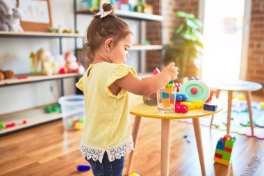 Anaokulundaki oyuncaklarla oynayan güzel bir çocuk.