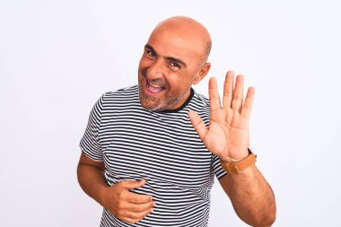 Orta yaşlı yakışıklı, çizgili donanma tişörtü giyen, izole edilmiş beyaz bir arka planı olan mutlu ve güler yüzlü, dostça bir jest yapan bir adam.