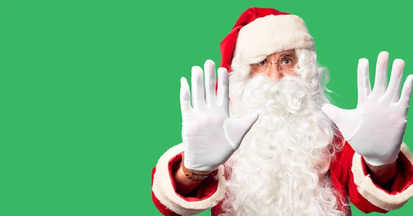 中年男子 身穿圣诞老人服装 蓄着胡子 站在那里 用手掌 愤怒和沮丧的表情做着停下来的手势 — 图库照片