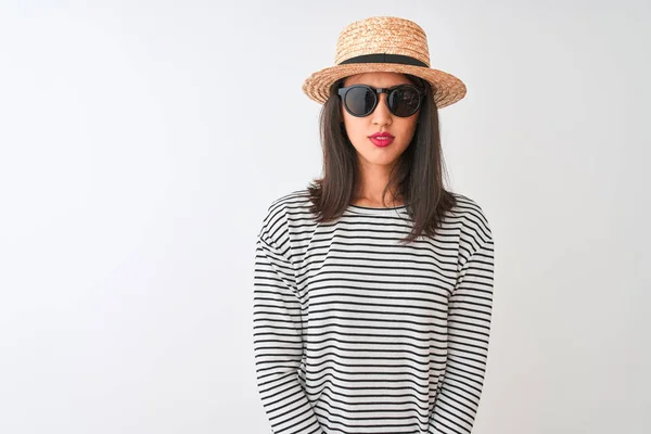 中国女人戴着条纹T恤帽太阳镜 站在孤立的白色背景上 脸上带着严肃的表情 简单而自然地看着相机 — 图库照片