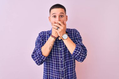 Soyutlanmış arka planda duran yakışıklı genç bir adam ağzını yanlışlıkla ellerle kapatarak şok geçirdi. Gizli konsept.