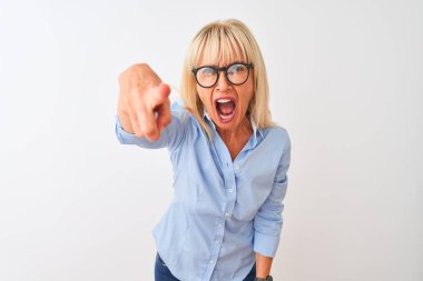 Orta yaşlı iş kadını zarif bir gömlek ve gözlük takıp izole edilmiş beyaz bir arka plana bakıyor. Kameraya kızgın ve sinirli bir şekilde bakıyor.