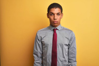 Gömlek ve kravat takan genç yakışıklı Arap işadamı, izole edilmiş sarı arka planda depresif ve endişe içinde, kızgın ve korkmuş bir şekilde ağlıyor. Üzücü ifade.