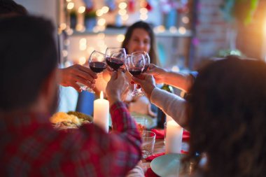 Mutlu ve kendinden emin gülümseyen güzel bir aile. Kızarmış hindi yemek ve evde Noel 'i kutlamak için bir bardak şarapla kadeh kaldırmak.