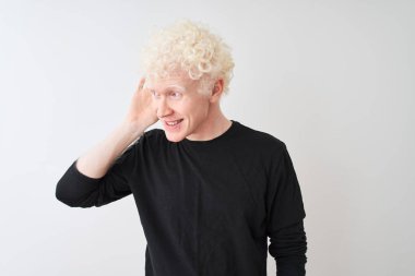 Siyah tişörtlü genç, albino sarışın adam izole edilmiş beyaz arka planda dikiliyor. Kulağı kulağında bir söylenti ya da dedikoduları dinliyor. Sağırlık kavramı.