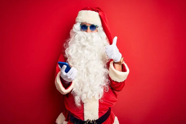 Старший Чоловік Костюмі Санта Клауса Використанням Смартфона Над Ізольованим Червоним — стокове фото