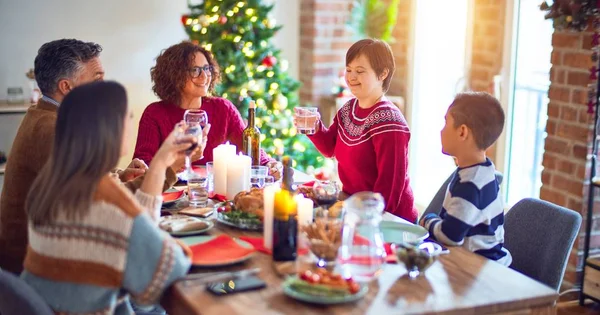 美丽的家庭喜形于色 对庆祝充满了信心 其中一个人站在那里 举着一杯水 在家里庆祝圣诞节 — 图库照片