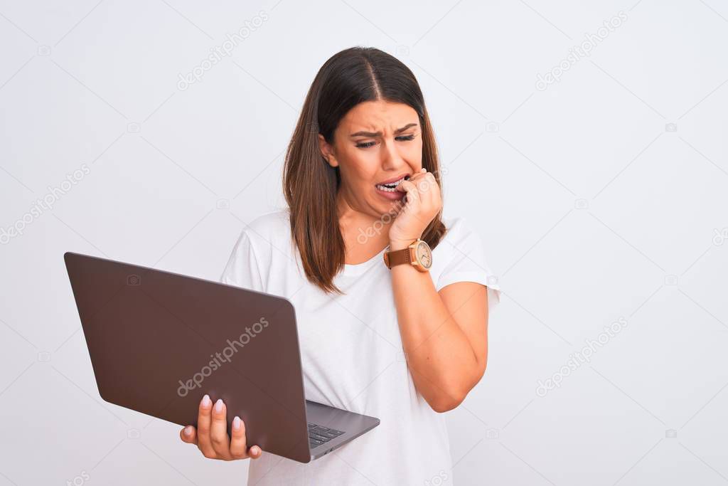 Beautiful young woman working using computer laptop over white background looking stressed and nervous with hands on mouth biting nails. Anxiety problem.