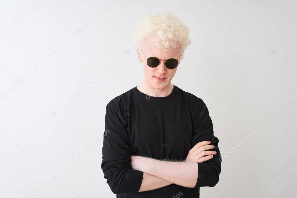 Young albino man wearing black t-shirt and sunglasess standing over isolated white background skeptic and nervous, disapproving expression on face with crossed arms. Negative person.
