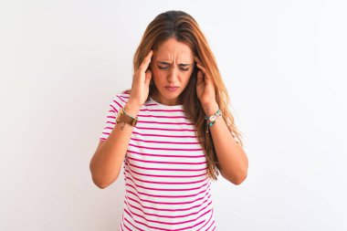 Genç kızıl saçlı kadın, çizgili günlük tişört giyiyordu. İzole edilmiş beyaz bir arkaplanda el ele tutuşarak stres yüzünden başını ağrıtıyordu. Migren ağrısı..