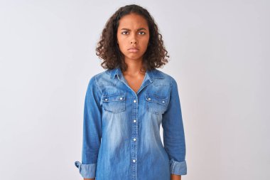 İzole edilmiş beyaz arka plan üzerinde duran Brezilyalı genç bir kadın şüpheci ve gergin, sorun yüzünden surat asıyor. Negatif kişi.