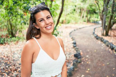 Güneşli bir yaz gününde yeşil parkta mutlu ve neşeli gülümseyen güzel bir kadın.