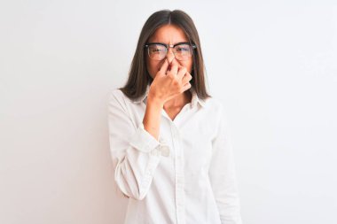 İzole edilmiş beyaz arka planda duran gözlük takan genç ve güzel bir iş kadını pis ve iğrenç bir koku alıyor. Dayanılmaz bir koku. Kötü koku konsepti.