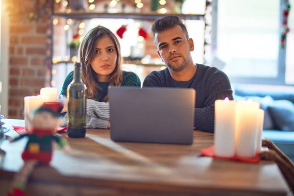 Junge Schöne Paar Sitzt Mit Laptop Weihnachtsdekoration Hause Skeptisch Und — Stockfoto