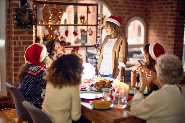 一群漂亮的女人开心而自信地微笑着 他们中的一个举着酒杯在家里庆祝圣诞节的讲演 — 图库照片