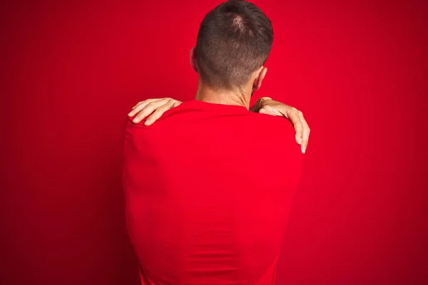 Jovem Homem Bonito Vestindo Camiseta Casual Sobre Fundo Vermelho Isolado — Fotografia de Stock