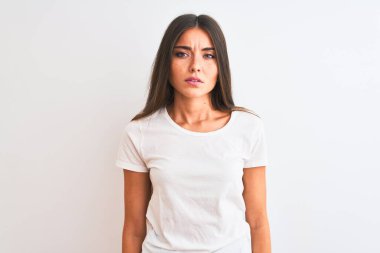 İzole edilmiş beyaz arka plan üzerinde duran sıradan tişört giyen genç ve güzel bir kadın uykulu ve yorgun görünüyor, yorgunluktan yorgun ve akşamdan kalma, sabahları tembel gözler.