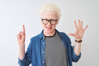 Genç albino sarışın adam kot gömlek ve gözlük takıyor izole edilmiş beyaz arka plan üzerinde altı numaralı parmaklarıyla işaret ederken kendinden emin ve mutlu gülümsüyor..