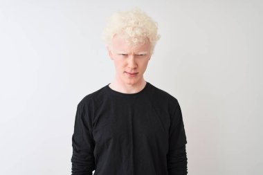 Siyah tişört giyen genç albino sarışın adam izole edilmiş beyaz arka plan üzerinde duruyor şüpheci ve gergin, sorun yüzünden üzgün. Negatif kişi.