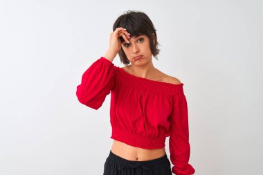 Kırmızı yaz tişörtü giyen genç ve güzel bir kadın izole edilmiş beyaz arka planda duruyor. Alnındaki sorun yüzünden endişeli ve stresli. Kriz için endişeli.