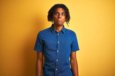 Rastgele kot gömlek giyen Afro bir adam izole edilmiş sarı arka planda duruyor. Depresyonda ve endişe içinde, sinirli ve korkmuş bir şekilde ağlıyor. Üzücü ifade.