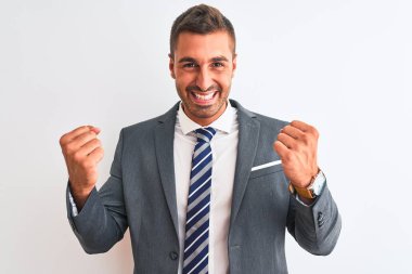 Takım elbiseli ve kravatlı genç yakışıklı iş adamı kolları havada ve gözleri kapalı zaferi kutlamak için heyecanla bekliyor. Kazanan konsept.