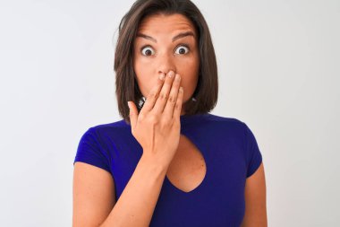 Mavi zarif bir tişört giyen genç bir kadın izole edilmiş beyaz arka planda duruyor. Ağzı kapalı. Yanlışlıkla utancından ağzı sarsılıyor.