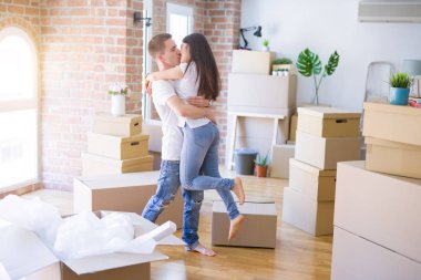 Karton kutular etrafında yeni evde sarılma genç güzel çift