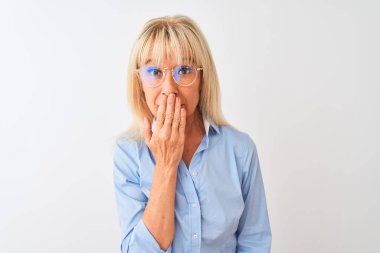 Gözlüklü ve gömlekli orta yaşlı bir iş kadını. İzole edilmiş beyaz arka plan üzerinde duruyor. Ağzı kapalı.