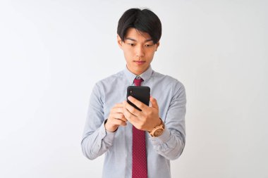 Çinli iş adamı kravat takıyor. Akıllı telefon kullanıyor. İzole edilmiş beyaz arka plan üzerinde duruyor.