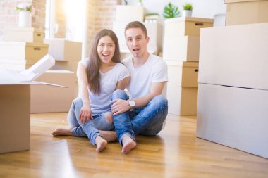 Genç ve güzel bir çift, yeni evlerinin etrafında karton kutuların etrafında oturuyor. Şaşırmış bir yüzle korkmuş ve korku ifadesinden korkmuşlar.