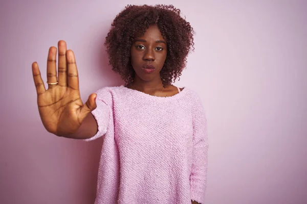 孤立したピンクの背景の上に立ってセーターを着て若いアフリカのアフロ女性は手の手のひらで歌うのを停止します 顔に負と深刻なジェスチャーで警告式 — ストック写真