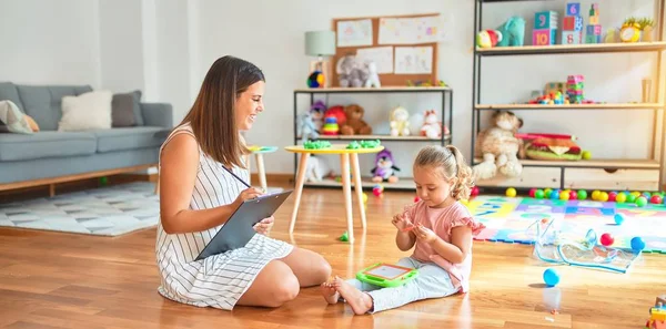 Schöne Lehrerin Und Blondes Kleinkind Bauen Turm Aus Plastikklötzen Kindergarten — Stockfoto