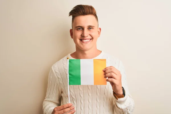 Młody Przystojny Mężczyzna Dzierżący Irlandzką Flagę Odizolowanym Białym Tle Szczęśliwą — Zdjęcie stockowe