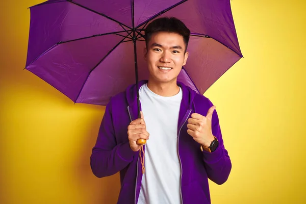 Asiático Chinês Homem Vestindo Roxo Guarda Chuva Sobre Isolado Amarelo — Fotografia de Stock